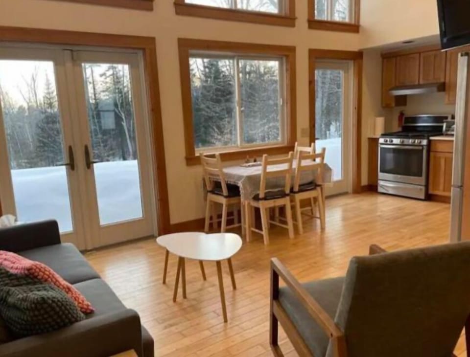 Open living room with french doors, huge windows & vaulted ceiling