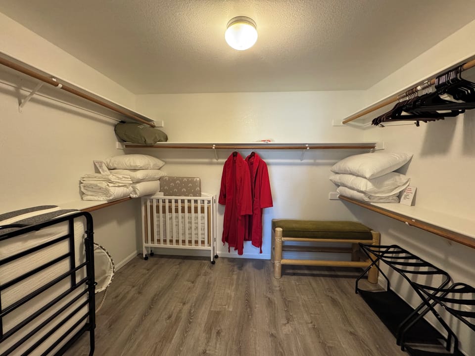 Master closet equipped with a rollaway bed, air mattress, crib and extra bedding