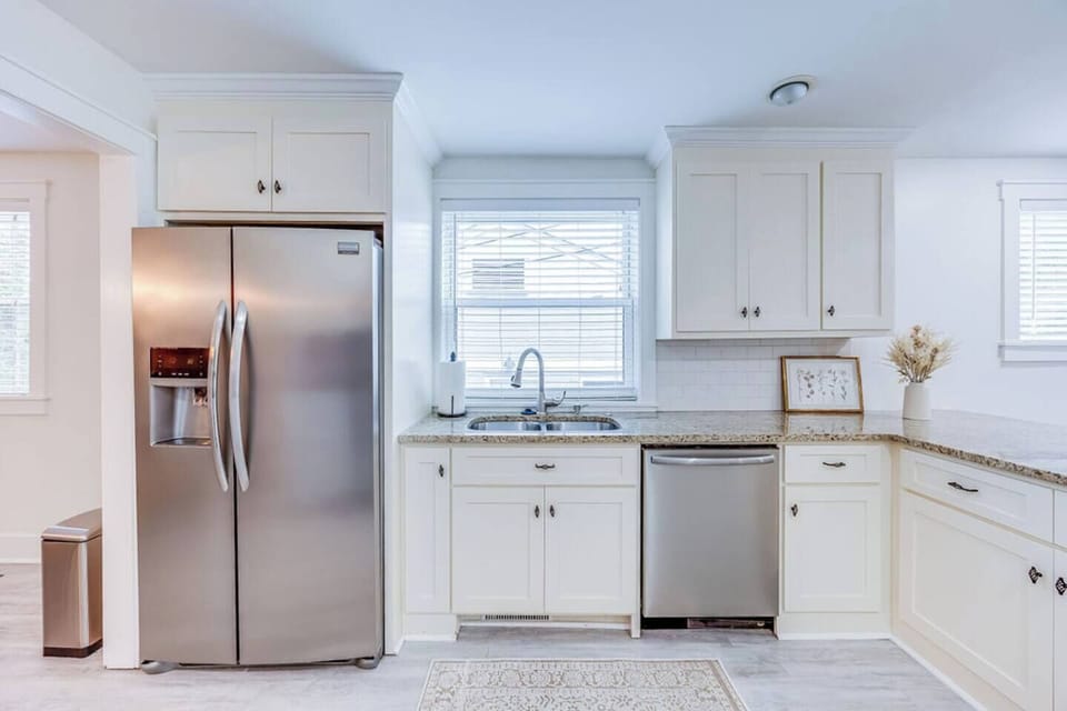 Fully equipped kitchen with sleek, white interiors, offering a bright and airy space to cook and gather.