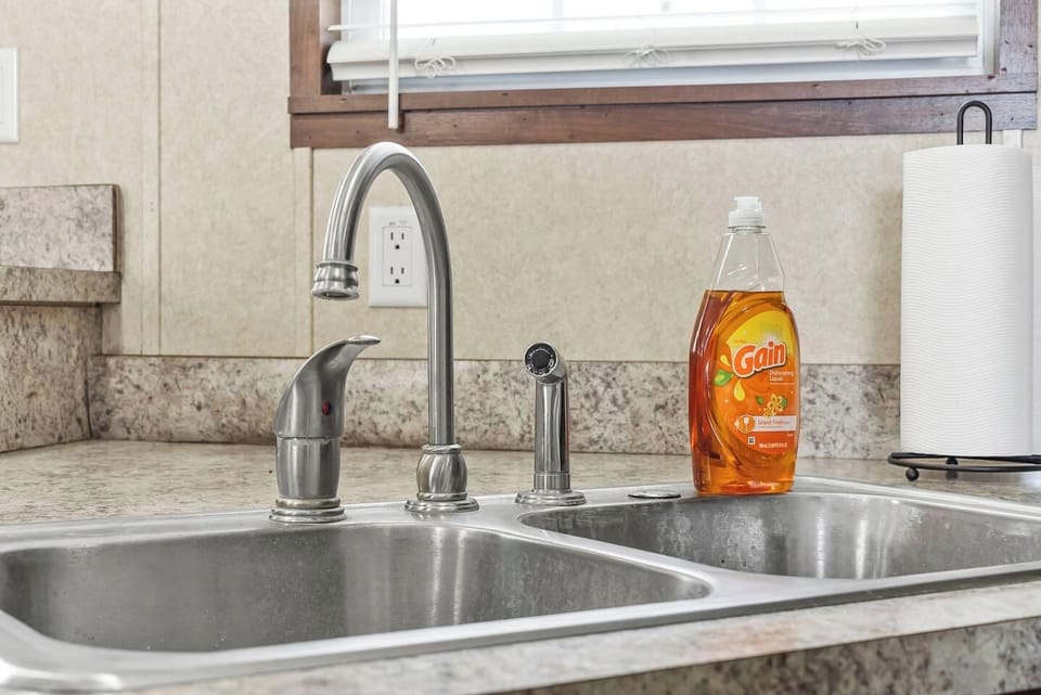 Close-up of the double sink with modern faucet and essentials—designed for convenience during your stay.