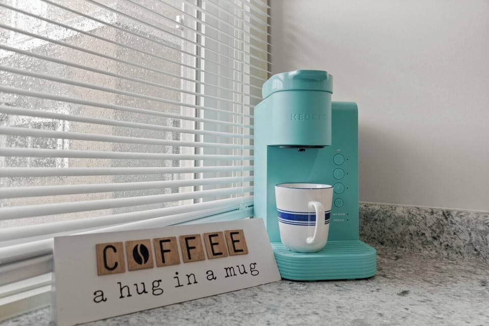 Charming full kitchen featuring a coffee maker alongside motivational quotes for coffee lovers, creating an inspiring atmosphere. Perfectly designed for brewing your favorite cup, blending style and functionality for an uplifting kitchen experience