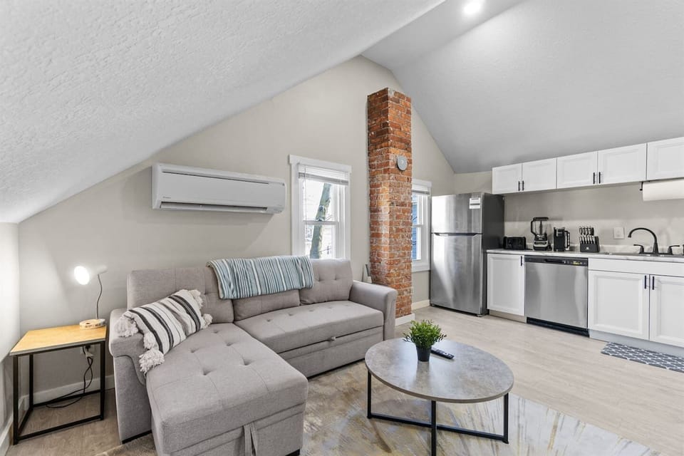 An upstairs living room featuring a sectional couch that easily transforms into a bed, offering additional sleeping space for guests.