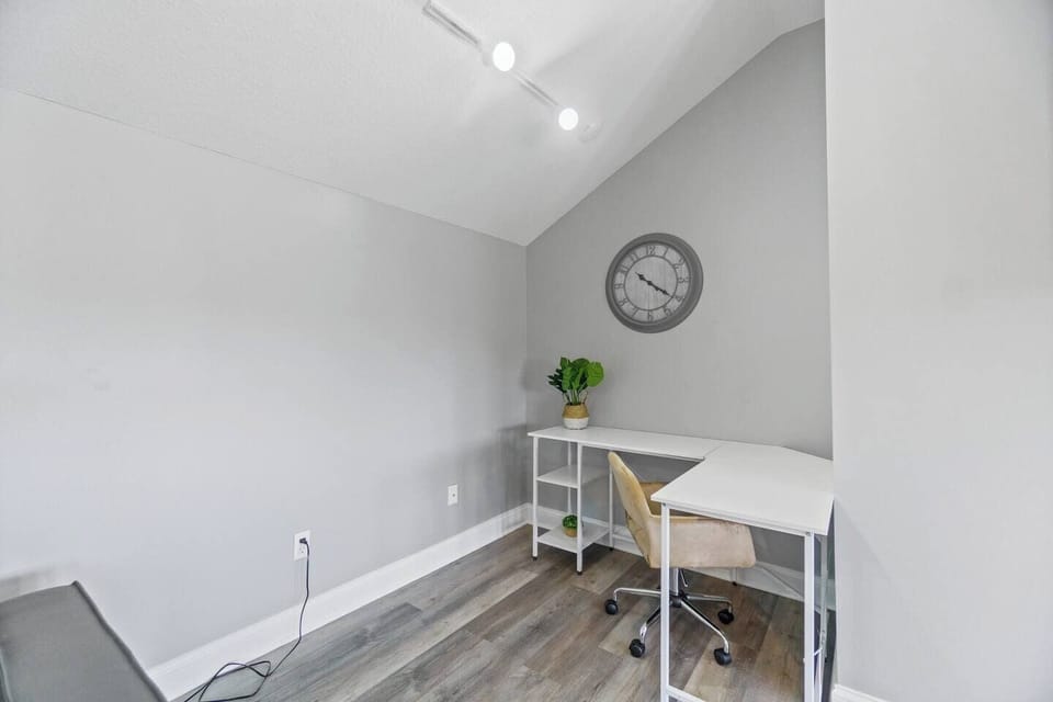 Dedicated workspace with a functional desk, comfortable chair, and ample lighting, perfect for productivity and focus.