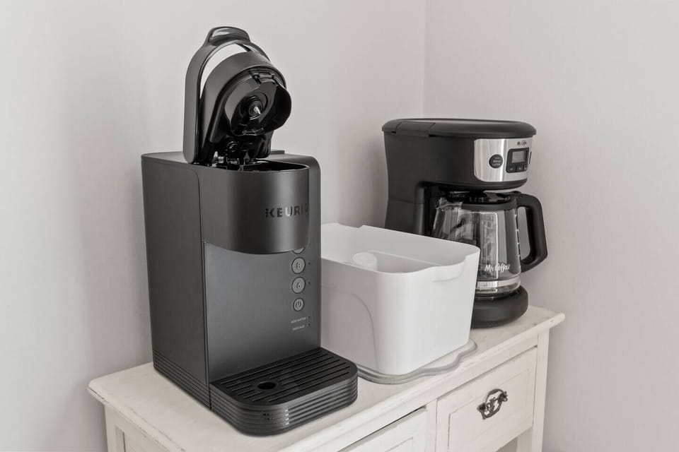 This cozy kitchen features a window that fills the space with natural light, a coffee maker for your daily brew, and a perfect view to enjoy while you cook.