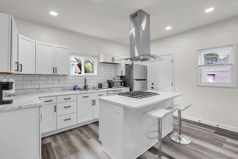 Enjoy the convenience of a center island with a burner, a modern sink, and a spacious fridge, all set in an elegantly designed kitchen for a functional and stylish cooking experience.
