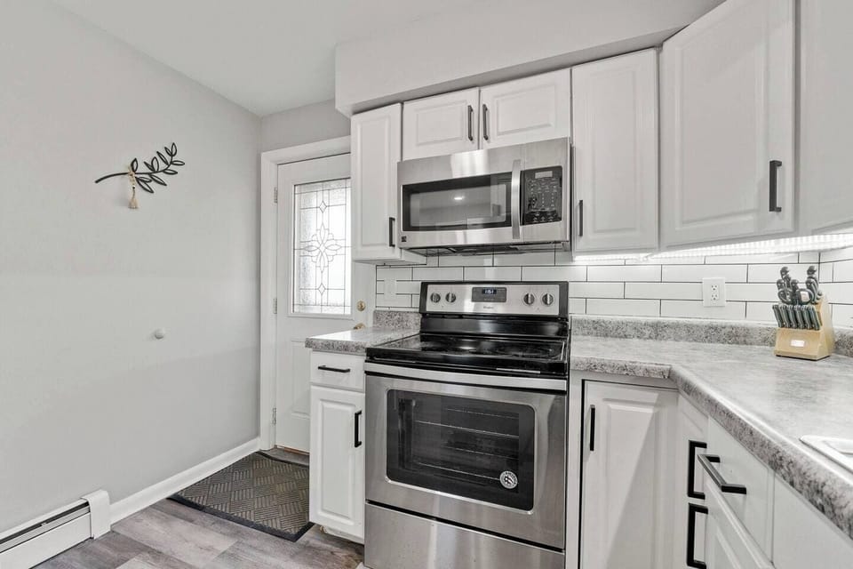 Sleek all-white kitchen with modern finishes, creating a bright and clean space for cooking and dining.