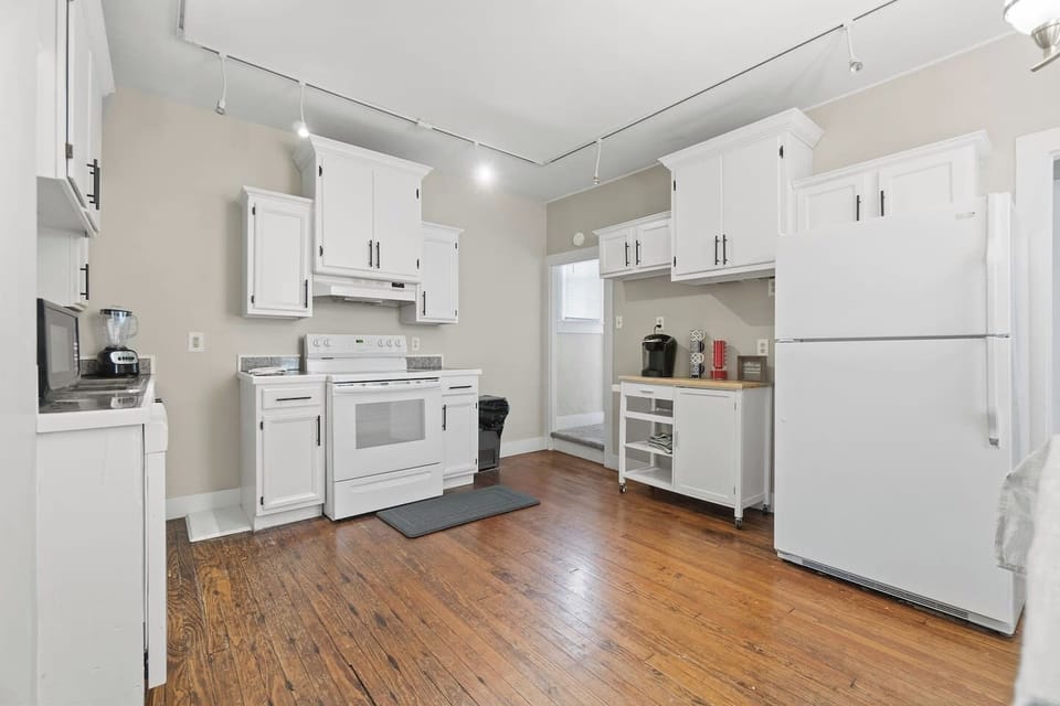Bright and modern full kitchen with all-white interiors, featuring sleek cabinetry, clean countertops, and top-of-the-line appliances for a fresh and stylish cooking experience.