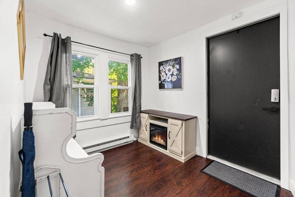 Welcoming entrance featuring a cozy fireplace, large windows for natural light, stylish decor, and a comfortable bench to settle in.