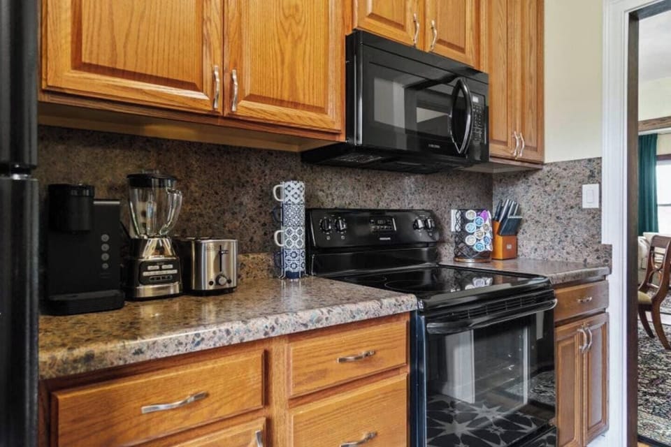 Fully equipped kitchen with a stove, microwave, blender, toaster, and coffee maker, providing everything you need for convenient cooking and dining.