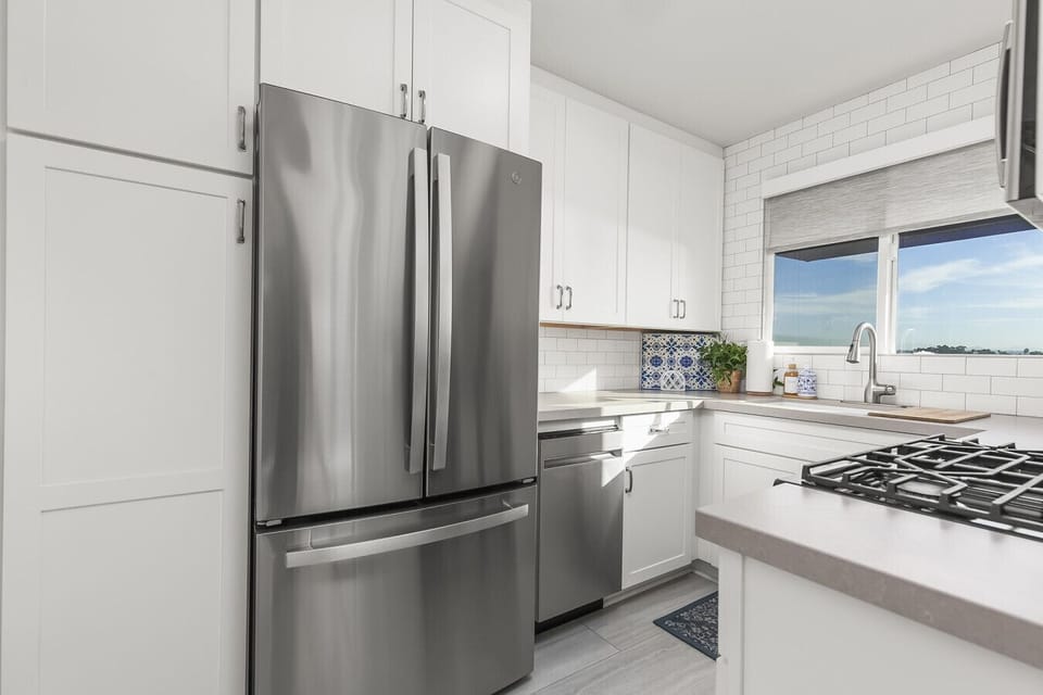 Fully stocked kitchen including Keurig machine, complimentary k-cups, creamers, spices, and a view.