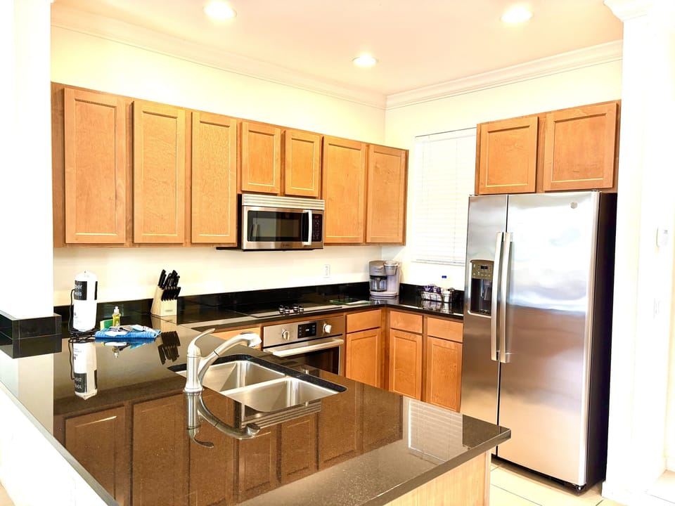 Fully appointed kitchen with solid surface countertops and stainless steel appliances