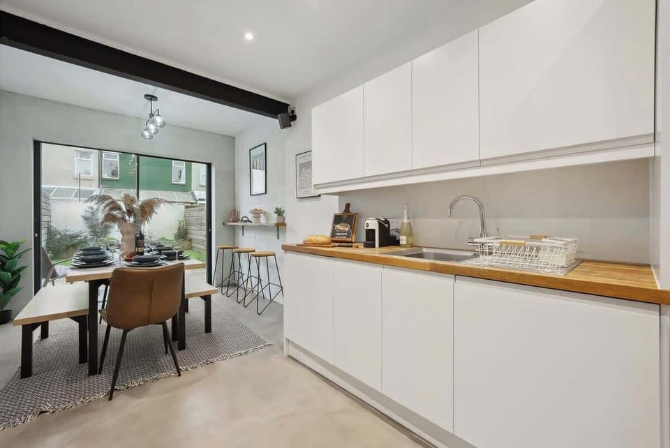 The open dining and kitchen area at Blue Puffin Stays Short Lets & Serviced Accommodation features a spacious sink, ideal for preparing your favourite family meals.