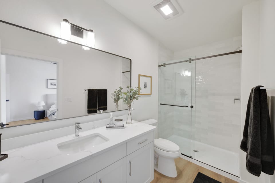 En-suite master bathroom with tile shower, stocked with shower essentials. 
