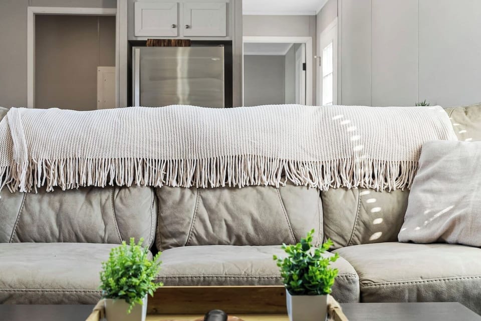 Close-up of the cozy sofa with soft throw blanket—designed for comfort and relaxation during your stay.