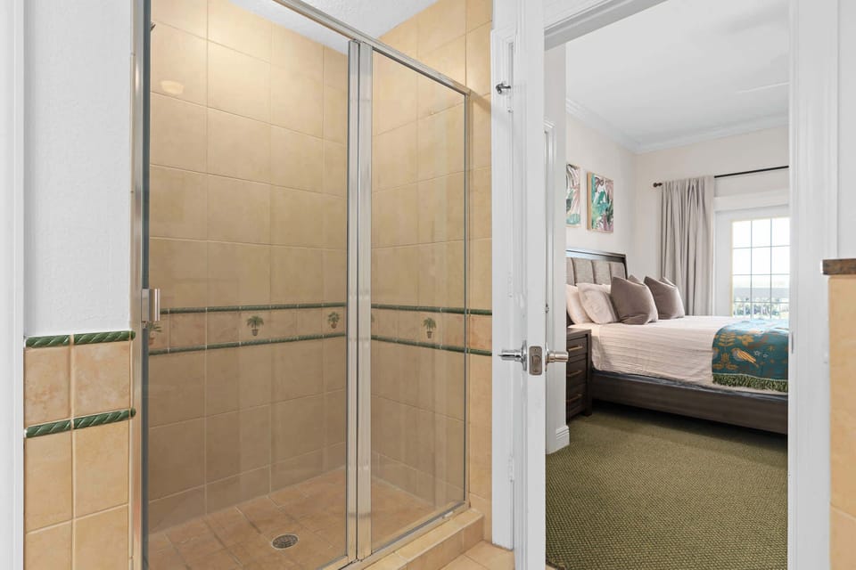 Walk-in shower with glass enclosure and elegant tiled walls.