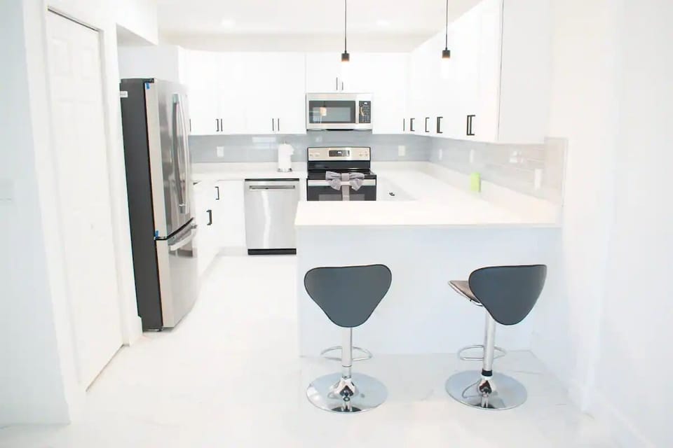 Fully Equipped Kitchen with Refrigerator and Dining Area 