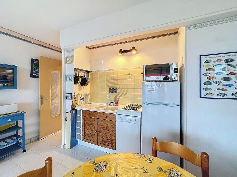 La cuisine rustique dégage une ambiance chaleureuse. Bien que compacte, elle est très fonctionnelle avec un lave-vaisselle pratique. Imaginez partager un repas convivial autour de la table en bois après une journée d'aventure.
