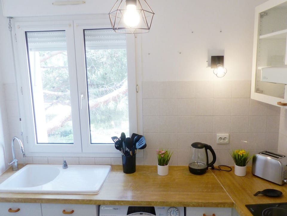 Dans cette cuisine moderne, préparez vos repas avec des appareils de qualité tout en admirant la vue dégagée par la grande fenêtre. Profitez de l'éclairage naturel qui illumine l'espace toute la journée.