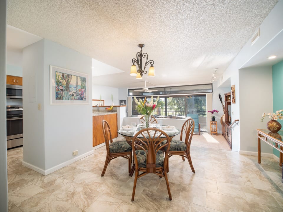 Gather with family and friends in the open-plan dining and living area, with natural light and tropical-inspired decor.