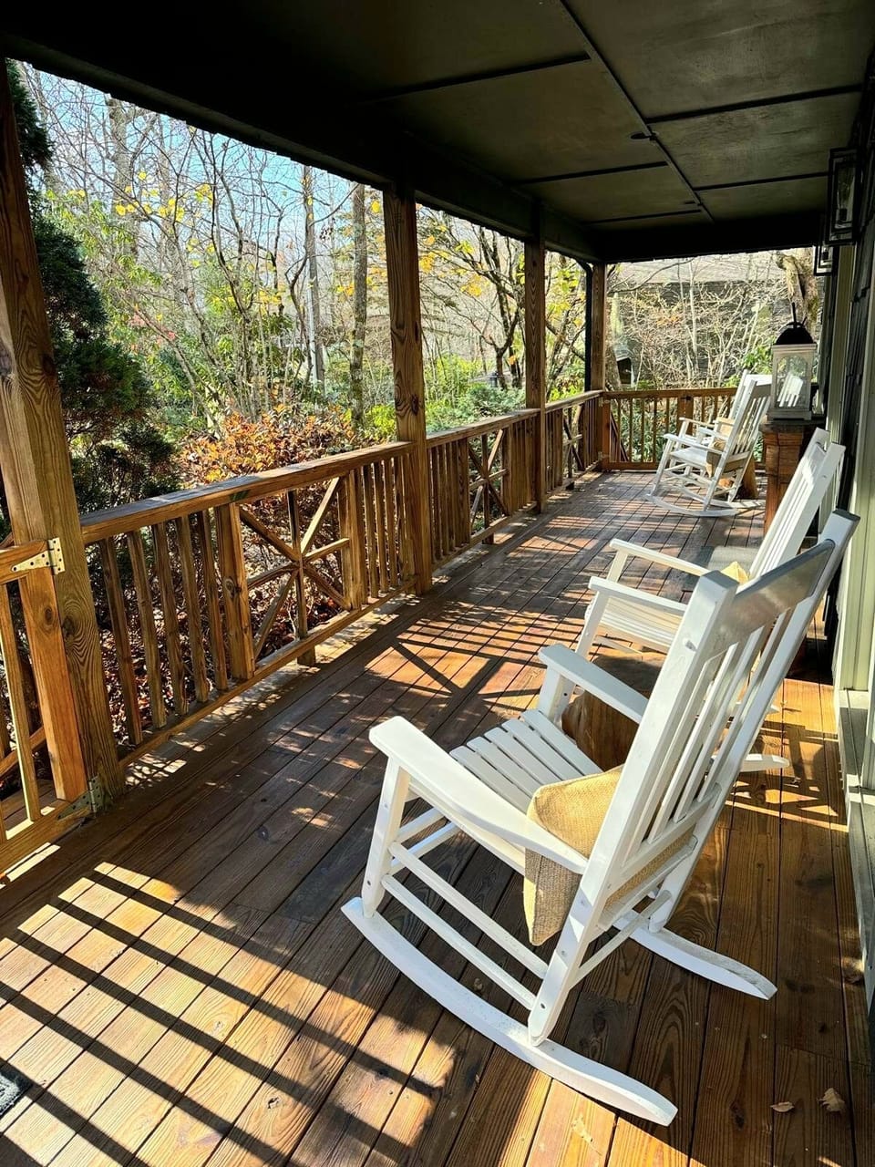 Wrap around covered porch with rocking chairs and grill