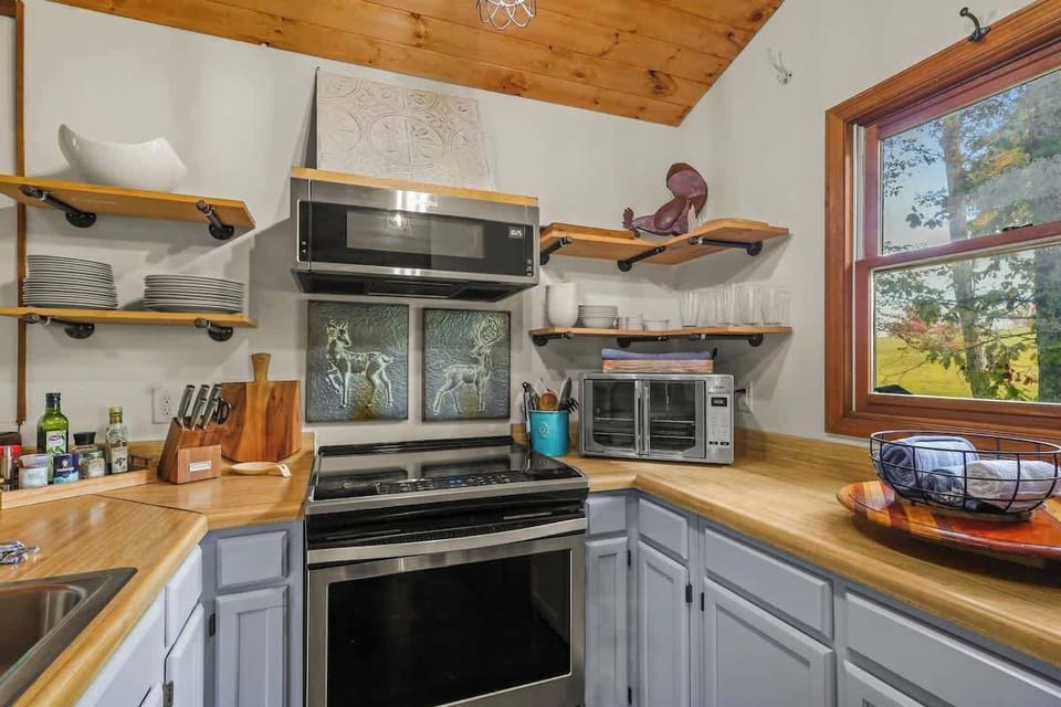 Effortless organization, rustic charm: Deer-engraved frame atop a sleek stove in a well-appointed kitchen