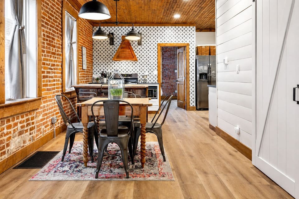 This polished angle presents the dining table, breakfast bar, and kitchen as one cohesive space.