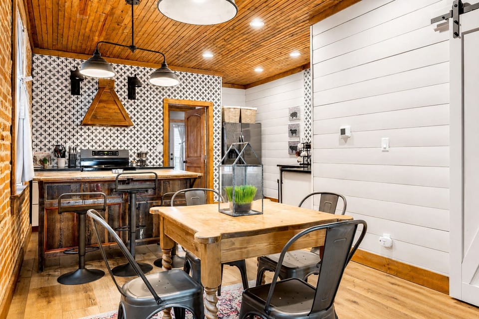 A compact dining table offers a convenient place to eat beside the breakfast bar.