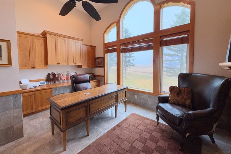 Off the living room is a gorgeous office, complete with a spacious desk, large windows, and a gas fireplace.