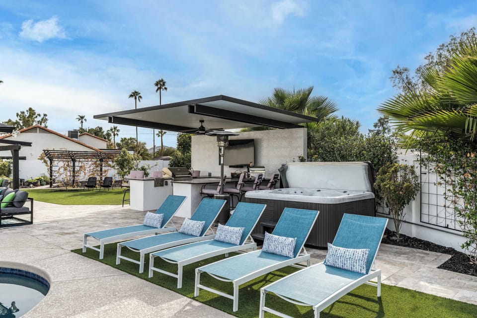 A welcoming outdoor pool area featuring chairs and tables, providing an ideal setting for relaxation, meals, and enjoying the pool.