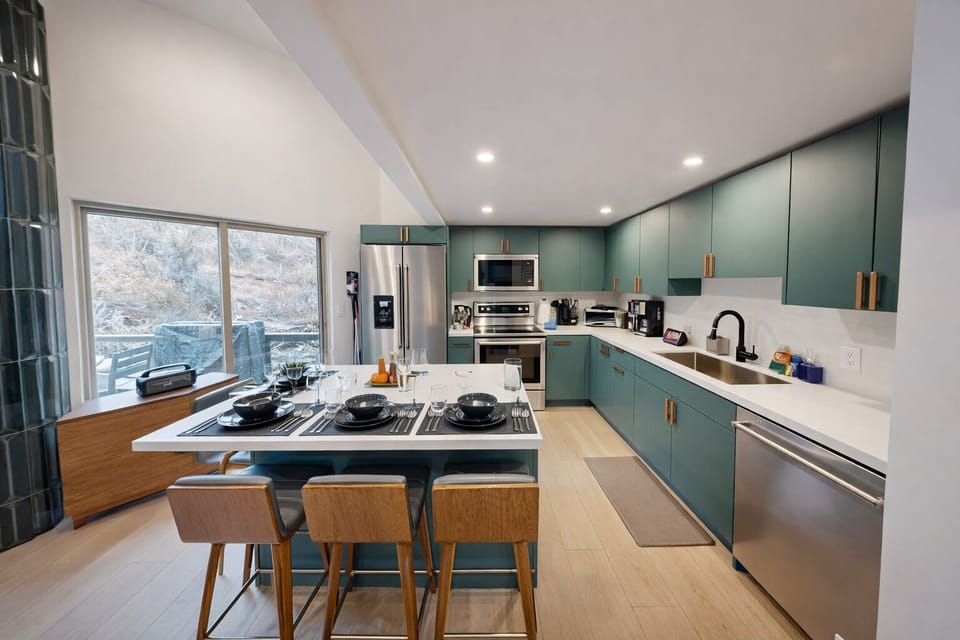 Your modern kitchen features sage green cabinets, white quartz countertops, and a breakfast island perfect for morning coffee while enjoying natural light.