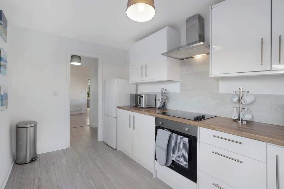 Kitchen equipped with all essentials, including a washer & dryer, oven, fridge and full cookware set.