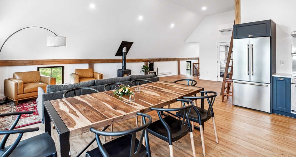 Open dining and living area warmed by a central wood stove
