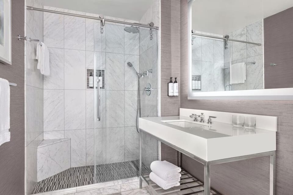 Refresh in a spa-like marble bath with a glass rain shower.