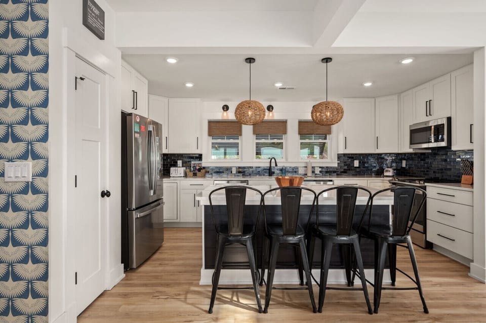 Modern kitchen w/ large island, bar seating & sleek finishes designed for cooking & connection.