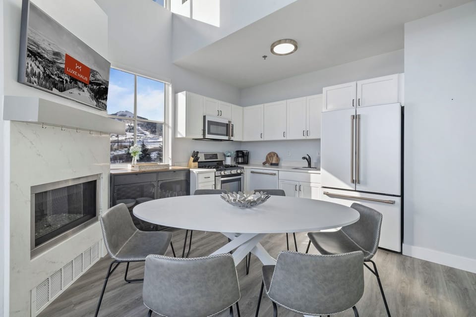 Modern kitchen and dining area with a fireplace and mountain views.