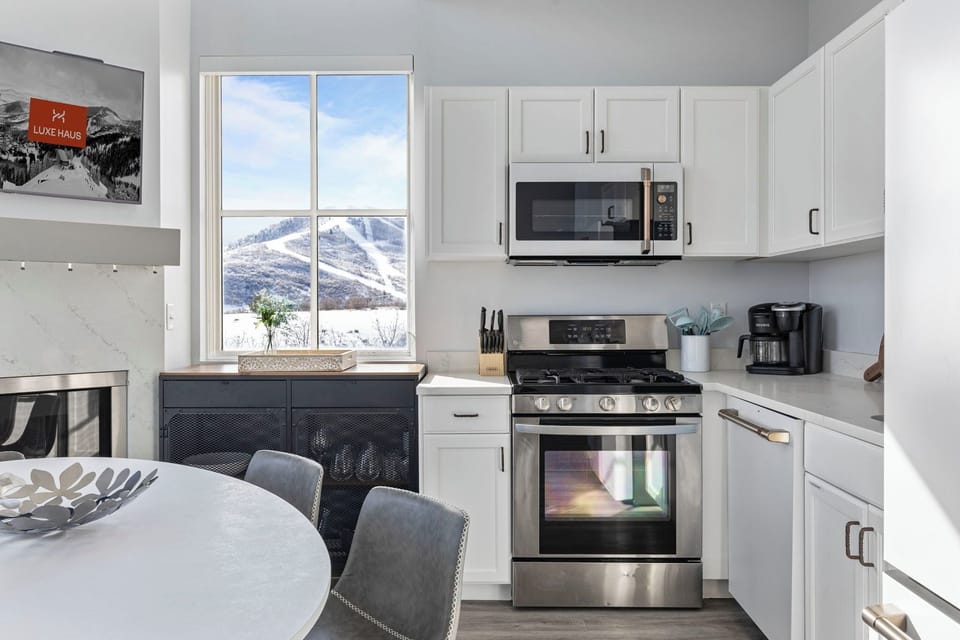 Sleek kitchen with mountain views and modern appliances.
