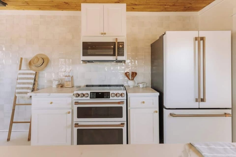 Luxury Cafe Appliances with a clean gold and white look. Plenty of storage place and a fully stocked kitchen with most of the utensils you will need for your stay!