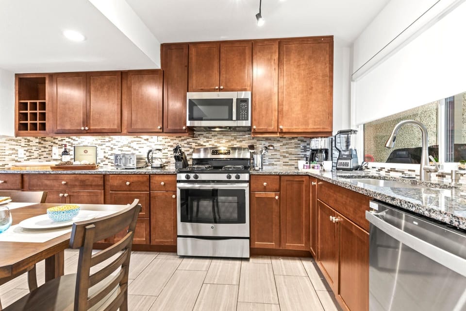    Modern kitchen with warm cabinetry and stainless steel appliances shining.