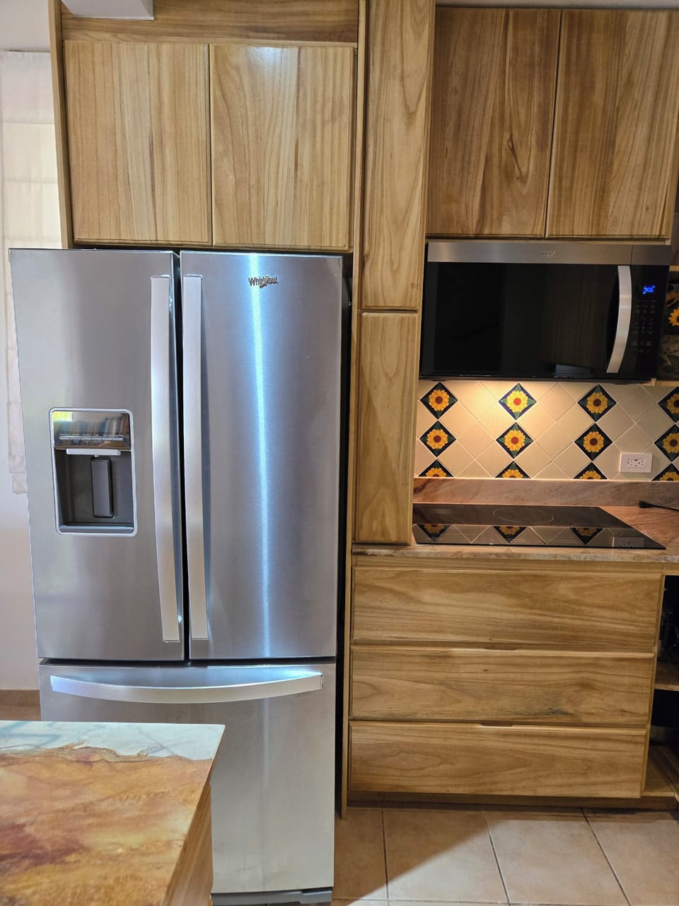 Modern kitchen with beautiful talavera tiled c back wall.