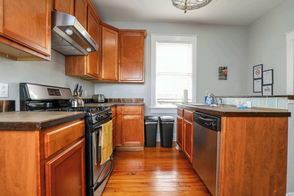 Kitchen featuring a full set of appliances, bar seating at the counter, and all the cookware, dishes, and utensils you could need.