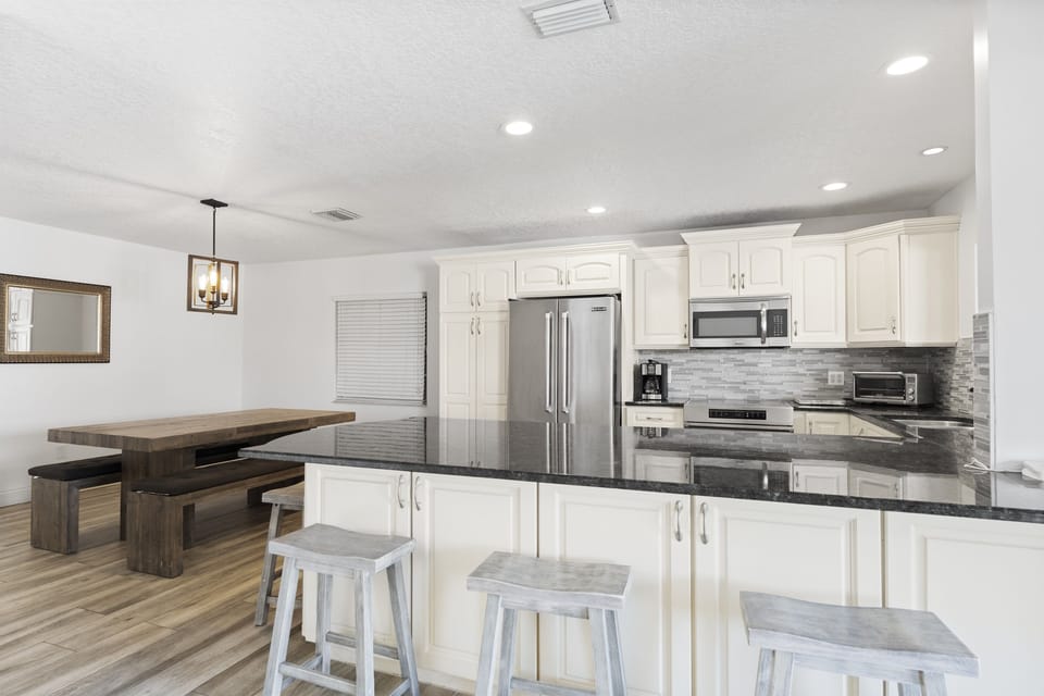 Modern kitchen featuring stainless steel appliances, granite countertops, and bar seating.