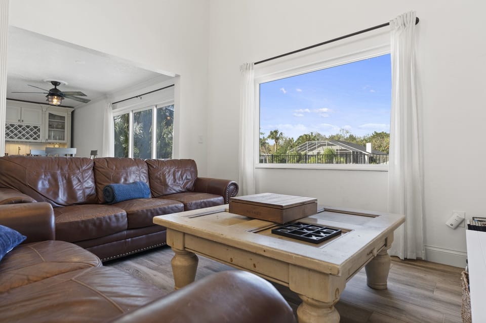 Spacious living room with large windows, natural light, and comfortable seating for the whole family.
