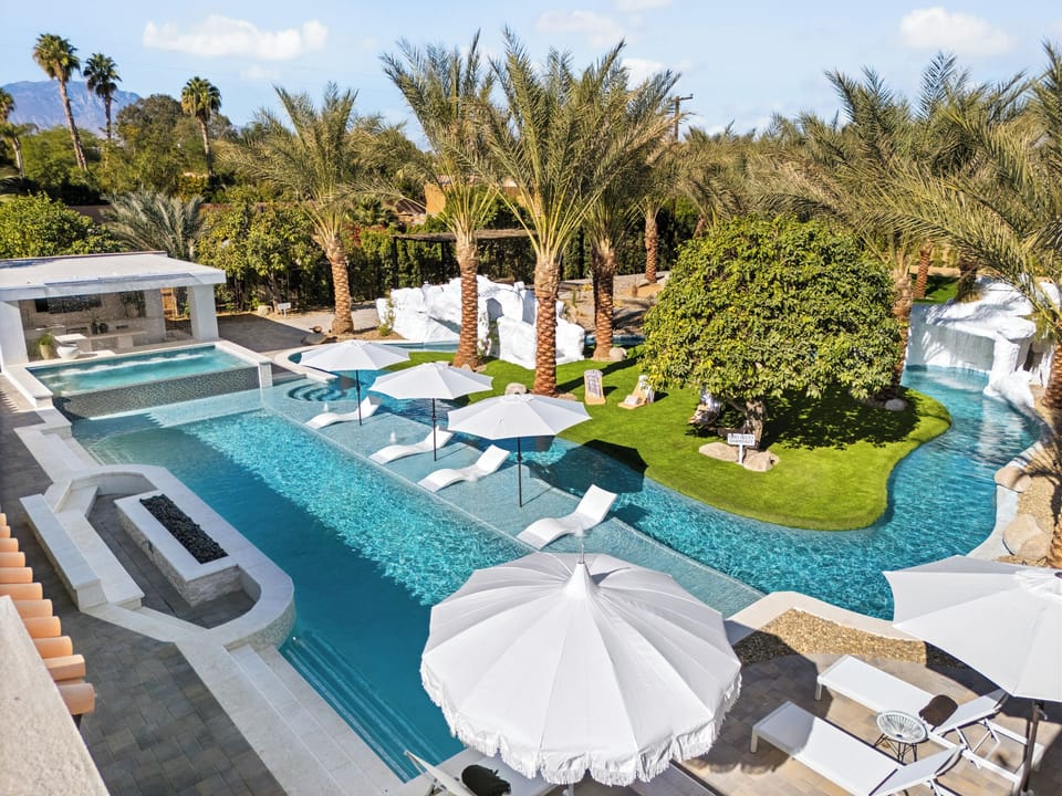 Lazy river pool featuring a waterslide, grotto and multiple waterfalls.