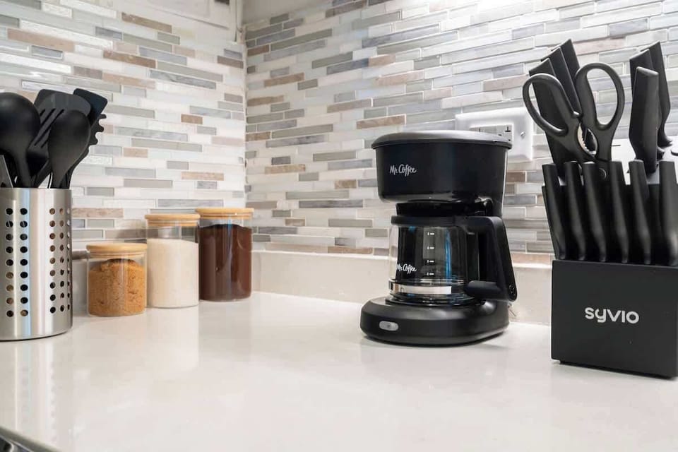 A clean modern kitchen with coffee maker and basic kitchen essentials.
