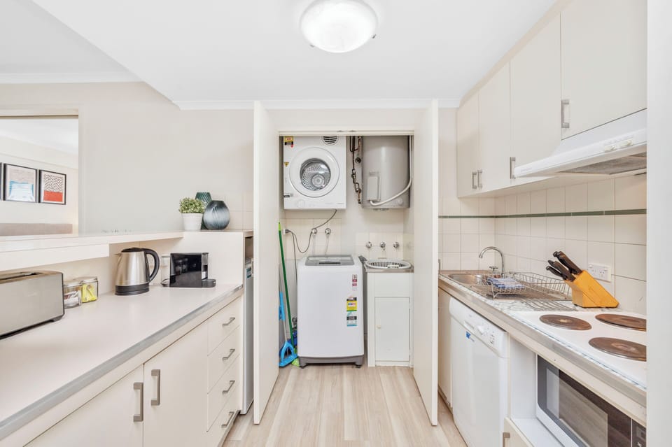 Experience the convenience of a well-equipped kitchen, complete with modern appliances, ample storage, and a laundry area for your comfort.