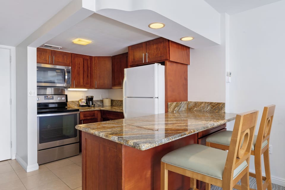 Your fully equipped kitchen features granite countertops, modern appliances, and a breakfast bar where you can enjoy morning coffee or casual meals together.