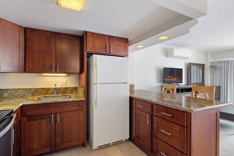 Your fully equipped kitchen features rich wood cabinetry, granite countertops, and modern appliances, making it easy to prepare meals during your stay.