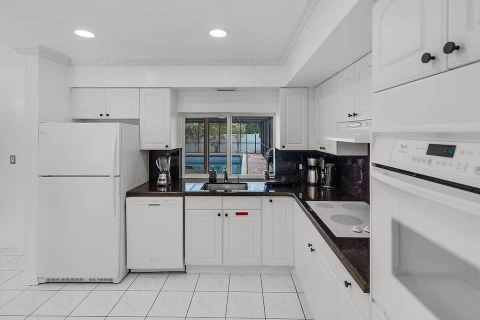 Bright, clean, and ready for your crew 🍳 This South Florida vacation rental kitchen features modern appliances, pool views, and plenty of counter space—perfect for families, groups, or long-term stays. Book your sunny escape today!