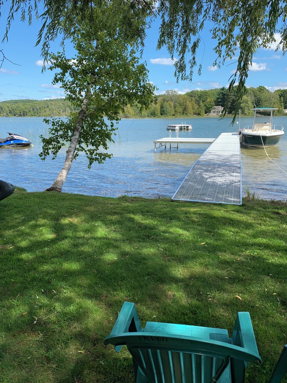 Sandy bottom swimming area with dock, raft, and space for boat.