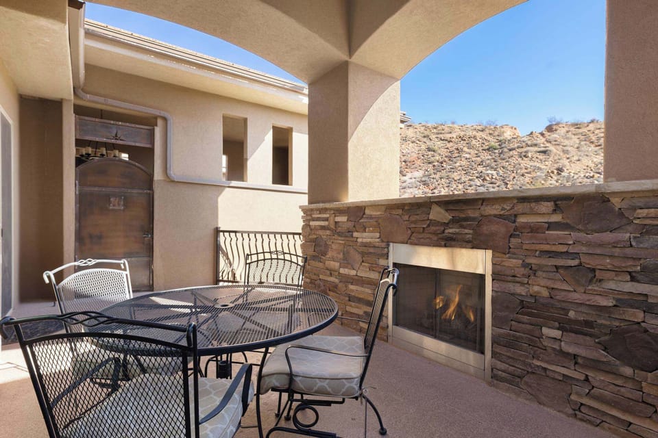 Private outdoor balcony with fireplace, gas grill, and dining table